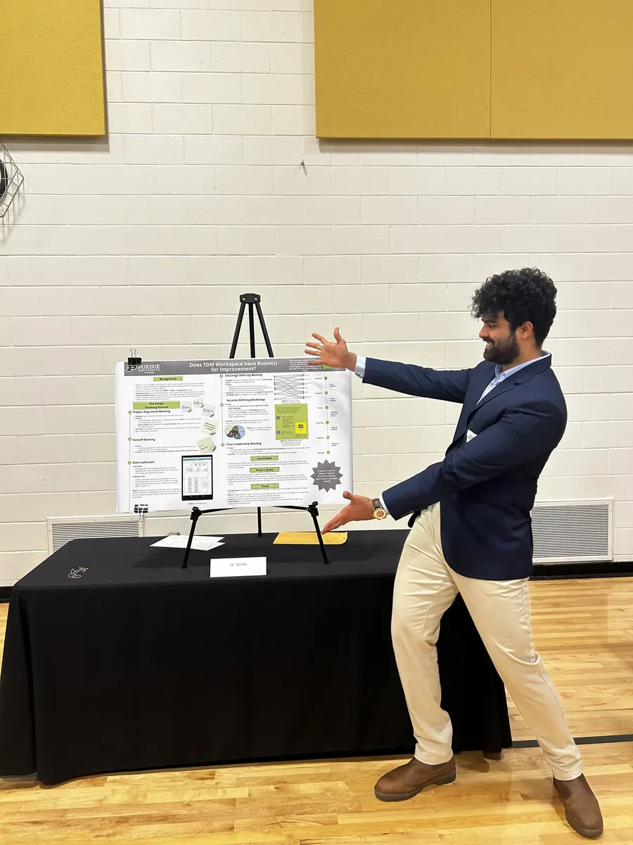 Presenting a UX research poster in a suit at a Purdue University symposium