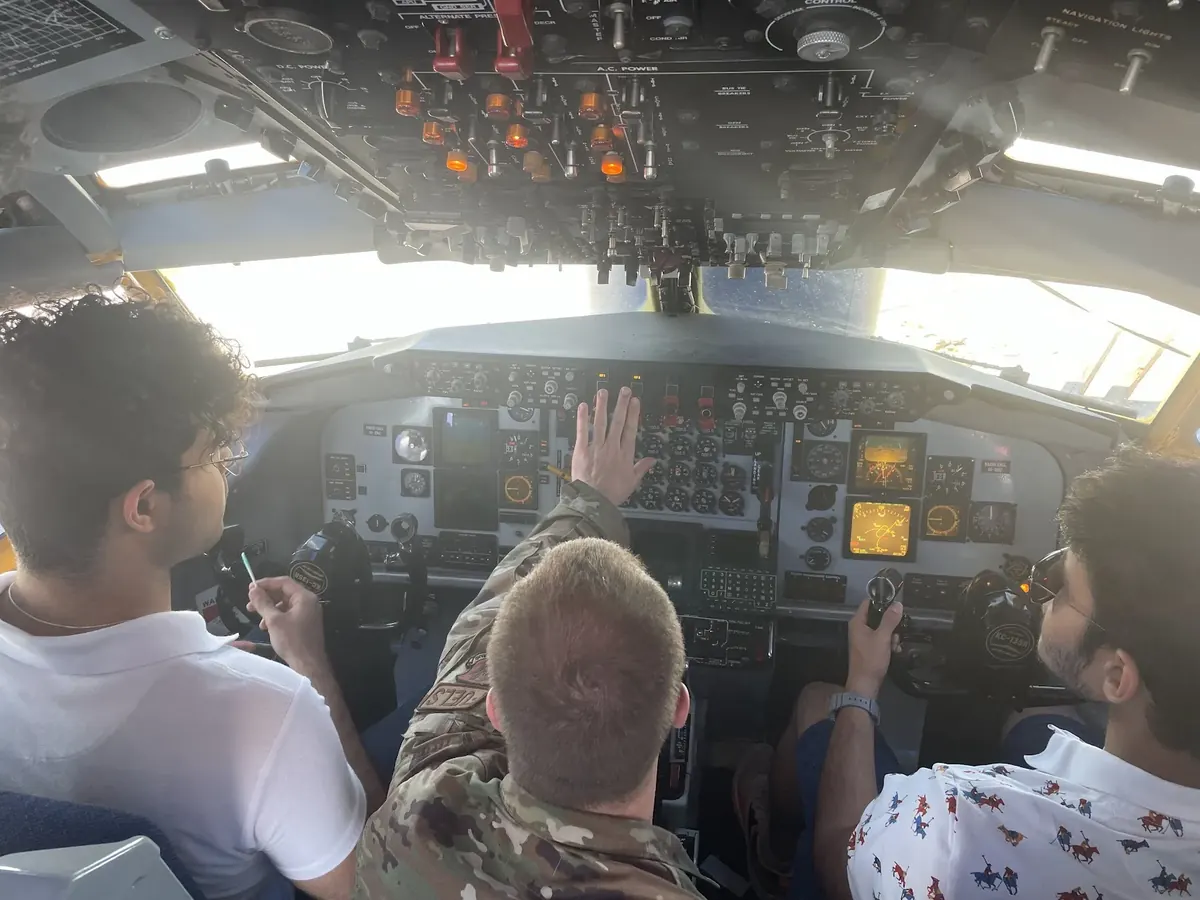 Sitting in the cockpit of an aircraft with two others during a tour