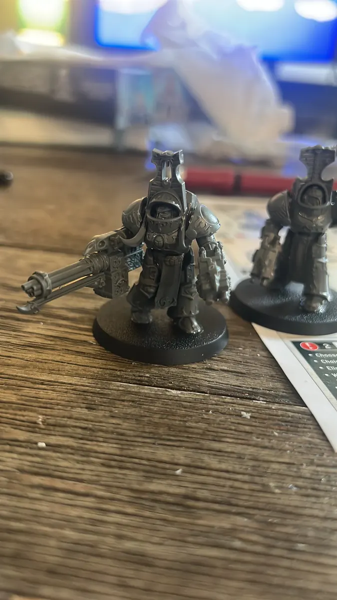 Close-up of unpainted tabletop miniatures on a workbench